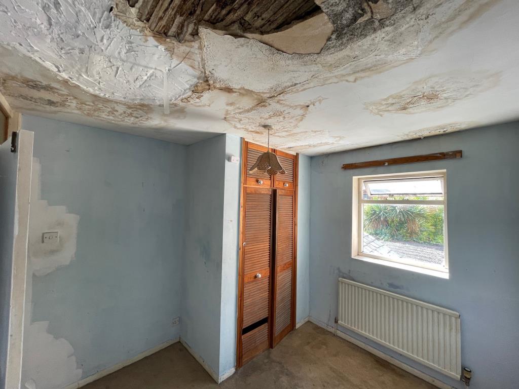 Lot: 144 - TERRACE HOUSE FOR IMPROVEMENT - Bedroom 2 with boiler cupboard and damaged ceiling